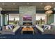 Beautiful lounge area with stone fireplace, comfortable seating, and view of the green outdoor space at 10322 E Topaz Ave, Mesa, AZ 85212