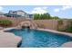 Backyard pool featuring a rock waterfall and slide, surrounded by lush landscaping at 10322 E Topaz Ave, Mesa, AZ 85212