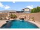 Lush backyard featuring a custom pool with a rock slide, ample lounging space, and privacy fence at 10322 E Topaz Ave, Mesa, AZ 85212