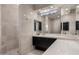 Bright bathroom with a black vanity, framed mirrors and a step-in shower with travertine tile at 10324 E Calle De Las Brisas --, Scottsdale, AZ 85255