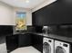 Spacious laundry room with black cabinetry, granite countertops, a sink, and modern washer and dryer at 10324 E Calle De Las Brisas --, Scottsdale, AZ 85255