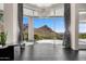 Bright living room with desert views from large floor-to-ceiling windows and modern lighting fixture at 10324 E Calle De Las Brisas --, Scottsdale, AZ 85255