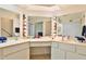 Bright bathroom featuring a skylight, tile floors and a long single sink vanity with many mirrors at 10421 E Silvertree Dr, Sun Lakes, AZ 85248