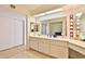 Bright bathroom featuring dual sinks, large mirrors, and a separate vanity area, offering a clean and functional design at 10421 E Silvertree Dr, Sun Lakes, AZ 85248