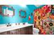 Colorful bathroom with double sinks, decorative mirrors, and a vibrant shower curtain at 10942 E Sonrisa Ave, Mesa, AZ 85212