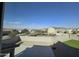 A view from a window overlooking a well-manicured backyard and the surrounding neighborhood on a sunny day at 10968 W Baden St, Avondale, AZ 85323