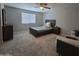 Bedroom featuring a ceiling fan, large windows, and neutral carpeting at 10968 W Baden St, Avondale, AZ 85323