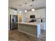 Modern kitchen featuring white cabinets, stainless steel appliances, and an island with pendant lighting at 10968 W Baden St, Avondale, AZ 85323