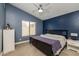 Cozy bedroom features blue walls and a wooden bed frame, creating a serene retreat at 1114 S Presidio Ave, Gilbert, AZ 85233