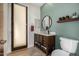 Bathroom vanity with a wooden cabinet, modern fixtures, and a round mirror at 11343 E Appaloosa Pl, Scottsdale, AZ 85259