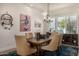 Inviting dining room featuring a rustic wood table, upholstered chairs, and modern light fixture at 11343 E Appaloosa Pl, Scottsdale, AZ 85259