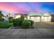 Stunning white home with a 3-car garage and beautiful desert landscaping at dusk at 11343 E Appaloosa Pl, Scottsdale, AZ 85259