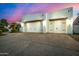 Three car garage with desert landscaping and a lovely pink and blue dusk sky at 11343 E Appaloosa Pl, Scottsdale, AZ 85259