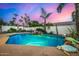 Backyard pool with a rock waterfall feature and lush landscaping, perfect for outdoor relaxation at 11343 E Appaloosa Pl, Scottsdale, AZ 85259