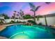 Sparkling pool with rock waterfall, surrounded by lush landscaping and a privacy fence at 11343 E Appaloosa Pl, Scottsdale, AZ 85259