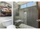 Modern shower stall with grey tiles, built-in shelving, and a glass door at 11343 E Appaloosa Pl, Scottsdale, AZ 85259