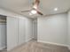 Bedroom features a ceiling fan, wall to wall closet and neutral colored walls and carpet at 114 E Garfield St, Tempe, AZ 85288