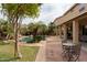 Beautiful backyard featuring a pool with rock features, desert landscaping, and a covered patio at 11868 W Kinderman Dr, Avondale, AZ 85323