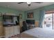 Bedroom with light green and beige walls, a ceiling fan, and a window with exterior home view at 11868 W Kinderman Dr, Avondale, AZ 85323