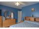 Cozy bedroom featuring blue walls, a ceiling fan, and matching light-wood furniture at 11868 W Kinderman Dr, Avondale, AZ 85323