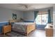 Comfortable bedroom showcasing two-tone walls, a bright window, wood floors, and soft lighting at 11868 W Kinderman Dr, Avondale, AZ 85323