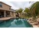 Resort-style pool featuring rock waterfall, desert landscaping and a covered patio in backyard at 11868 W Kinderman Dr, Avondale, AZ 85323