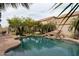 Private backyard oasis featuring a sparkling pool with rock features and desert landscaping at 11868 W Kinderman Dr, Avondale, AZ 85323