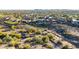 Wide aerial view of a neighborhood showcasing homes with pools, desert landscaping, and mountain views in the distance at 12918 W Caraveo Pl, Peoria, AZ 85383