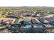 Expansive aerial view of a desert home and neighborhood featuring sparkling pools and lush landscaping at 12918 W Caraveo Pl, Peoria, AZ 85383