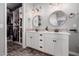 Bathroom with double vanity, decorative mirrors, and a large open closet for storage at 12918 W Caraveo Pl, Peoria, AZ 85383