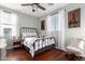 Well-lit bedroom with hardwood floors, a queen-sized bed, and window with decorative curtains at 12918 W Caraveo Pl, Peoria, AZ 85383