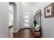 Bright entryway with dark wood floors, a modern coat rack, and views into a bedroom at 12918 W Caraveo Pl, Peoria, AZ 85383