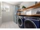 Well-organized laundry room with blue washer and dryer, custom cabinets, and ample storage at 12918 W Caraveo Pl, Peoria, AZ 85383