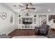 Comfortable living room with stylish decor, a large television, and hardwood flooring at 12918 W Caraveo Pl, Peoria, AZ 85383