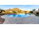 Backyard pool features desert landscaping, mountain views, and travertine tiling at 12918 W Caraveo Pl, Peoria, AZ 85383