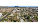 Expansive aerial view of a community featuring mature trees, residential homes, pools, and nearby commercial buildings at 1414 E Vermont Ave, Phoenix, AZ 85014