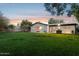 Expansive backyard featuring lush green lawn, patio with grill, and stylish exterior at 1414 E Vermont Ave, Phoenix, AZ 85014