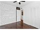 Bedroom featuring hardwood floors, black and white polka dot accent wall, shelving, and closet at 1414 E Vermont Ave, Phoenix, AZ 85014