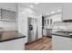 Modern kitchen featuring white cabinets, stainless steel appliances, and dark countertops at 1414 E Vermont Ave, Phoenix, AZ 85014