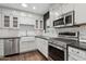 Bright kitchen featuring white cabinets, stainless steel appliances, a farmhouse sink, and dark countertops at 1414 E Vermont Ave, Phoenix, AZ 85014