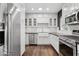 Modern kitchen with stainless steel appliances, white cabinets, subway tile backsplash, and hardwood floors at 1414 E Vermont Ave, Phoenix, AZ 85014