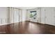 Bright living room with hardwood floors, white walls, wainscoting detail, and large windows at 1414 E Vermont Ave, Phoenix, AZ 85014