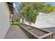 View of side yard featuring a long planter box along a block wall, adjacent to a concrete walkway at 1414 E Vermont Ave, Phoenix, AZ 85014