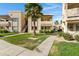 Well-maintained apartment complex exterior with lush green landscaping, sidewalks, and a blue sky at 145 N 74Th St # 121, Mesa, AZ 85207