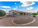 Low-maintenance backyard with gravel landscaping, patio, and charming details at 15116 W Carbine Way, Sun City West, AZ 85375