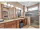 Elegant bathroom with double sinks, granite countertops, and a tiled shower at 15116 W Carbine Way, Sun City West, AZ 85375