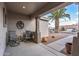 Inviting covered porch with comfortable seating, complemented by desert landscaping and a palm tree view at 15116 W Carbine Way, Sun City West, AZ 85375