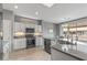 Modern kitchen with white cabinets, stainless steel appliances, and an island with a sink and seating at 15116 W Carbine Way, Sun City West, AZ 85375