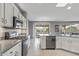 Bright, open kitchen with modern appliances, white cabinetry, and a seamless transition to the dining area at 15116 W Carbine Way, Sun City West, AZ 85375