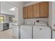 Practical laundry room featuring a modern washer and dryer, cabinet storage, and easy access to the kitchen at 15116 W Carbine Way, Sun City West, AZ 85375